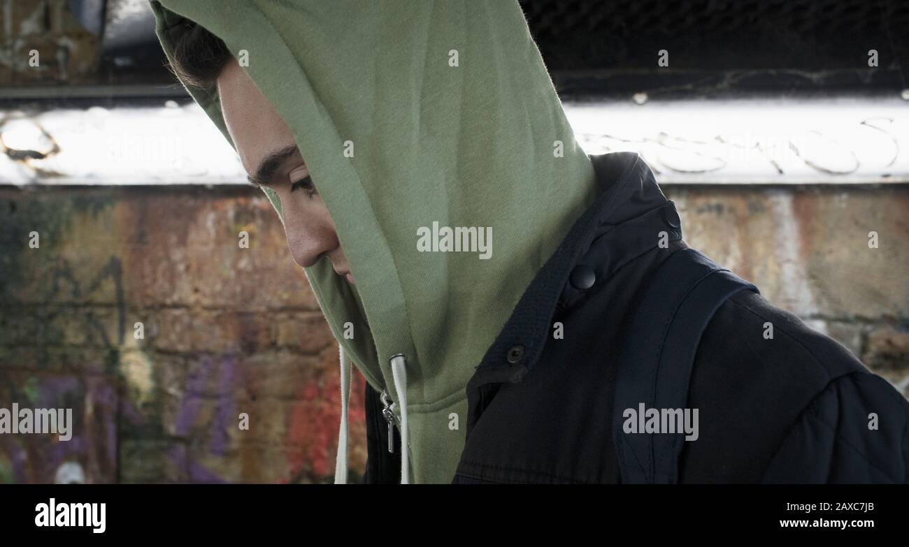 Serious young man wearing hoody in urban tunnel Stock Photo