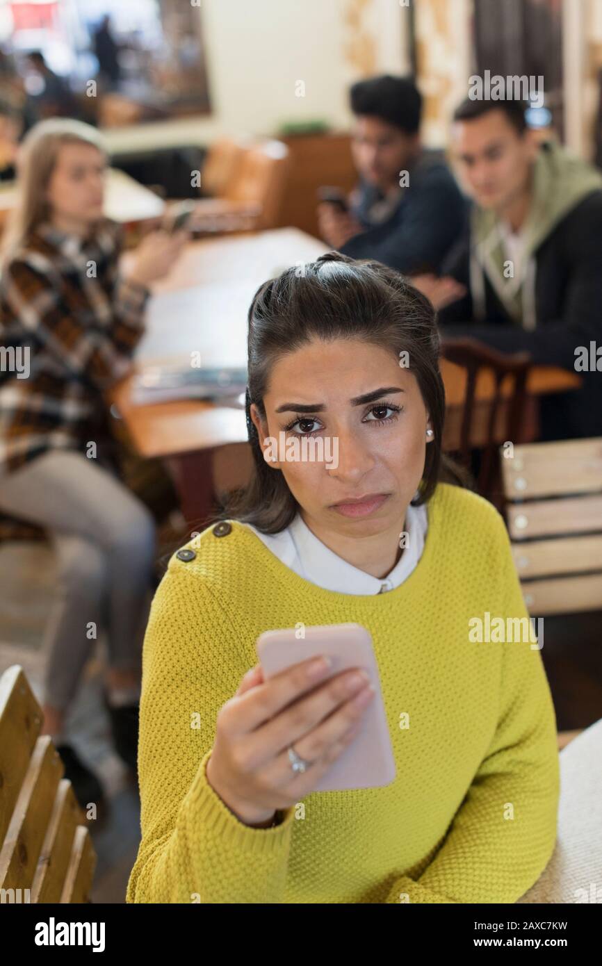 Portrait upset young woman with smart phone in cafe Stock Photo