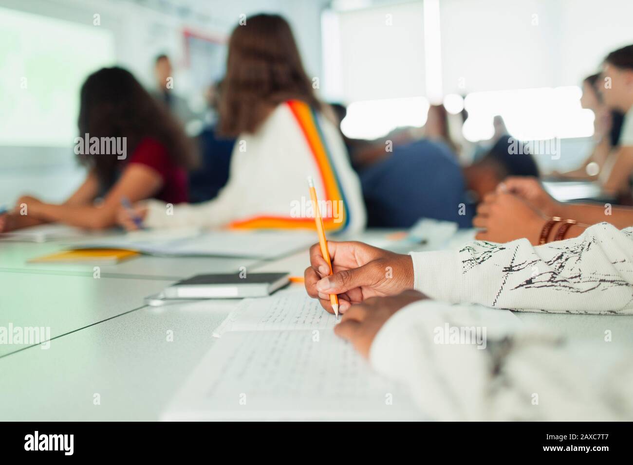 High school student studying, writing in notebook during lesson in classroom Stock Photo