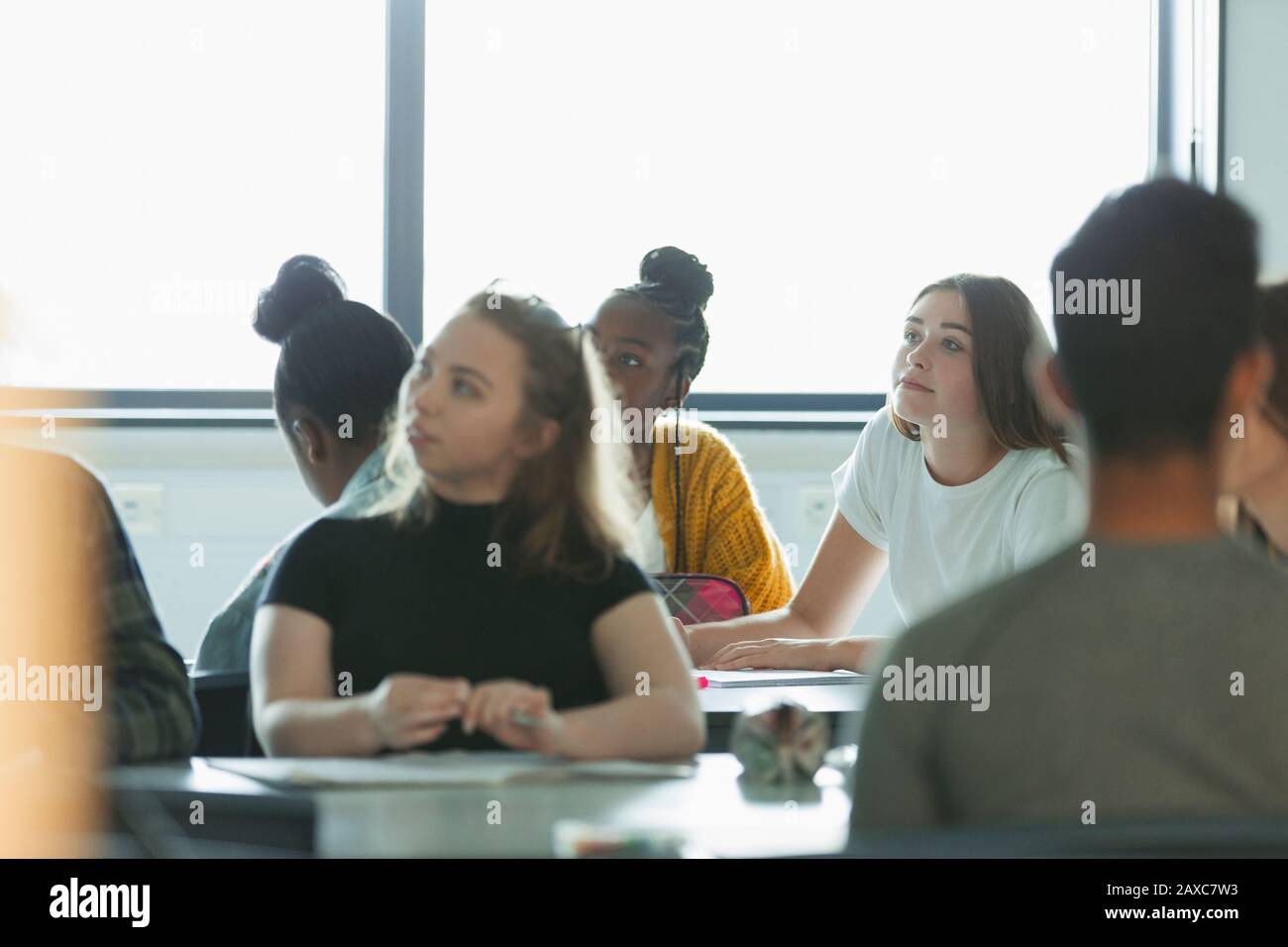 Attentive high school students listening in classroom Stock Photo