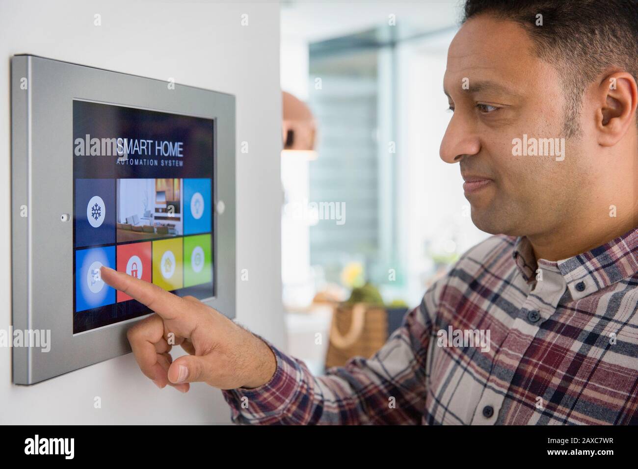 Man setting smart home navigation system alarm at touch screen Stock Photo