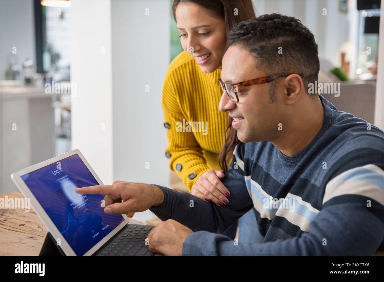 Couple using digital tablet, logging on with fingerprint Stock Photo