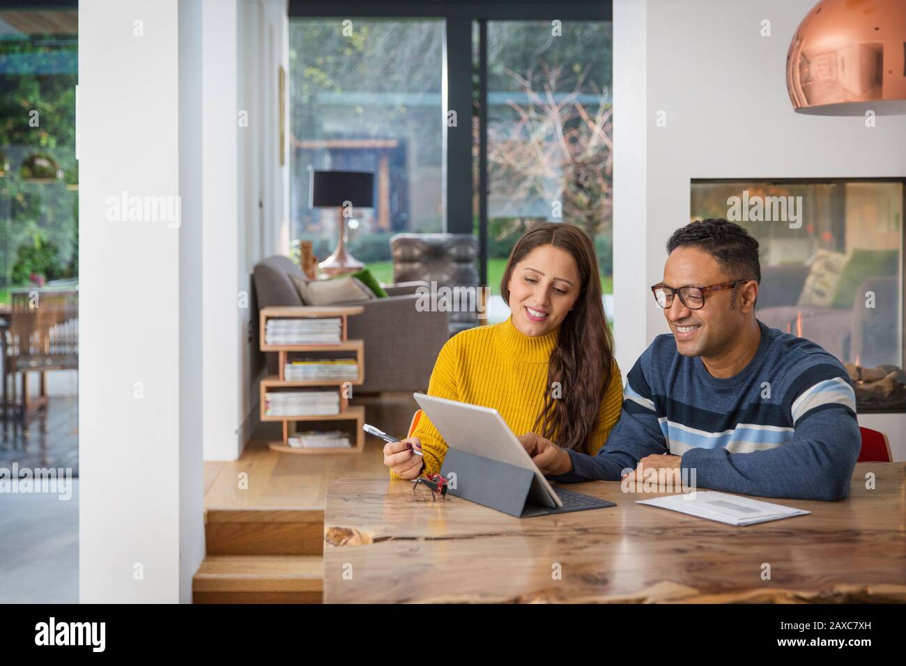 Couple paying bills at digital tablet at dining table Stock Photo