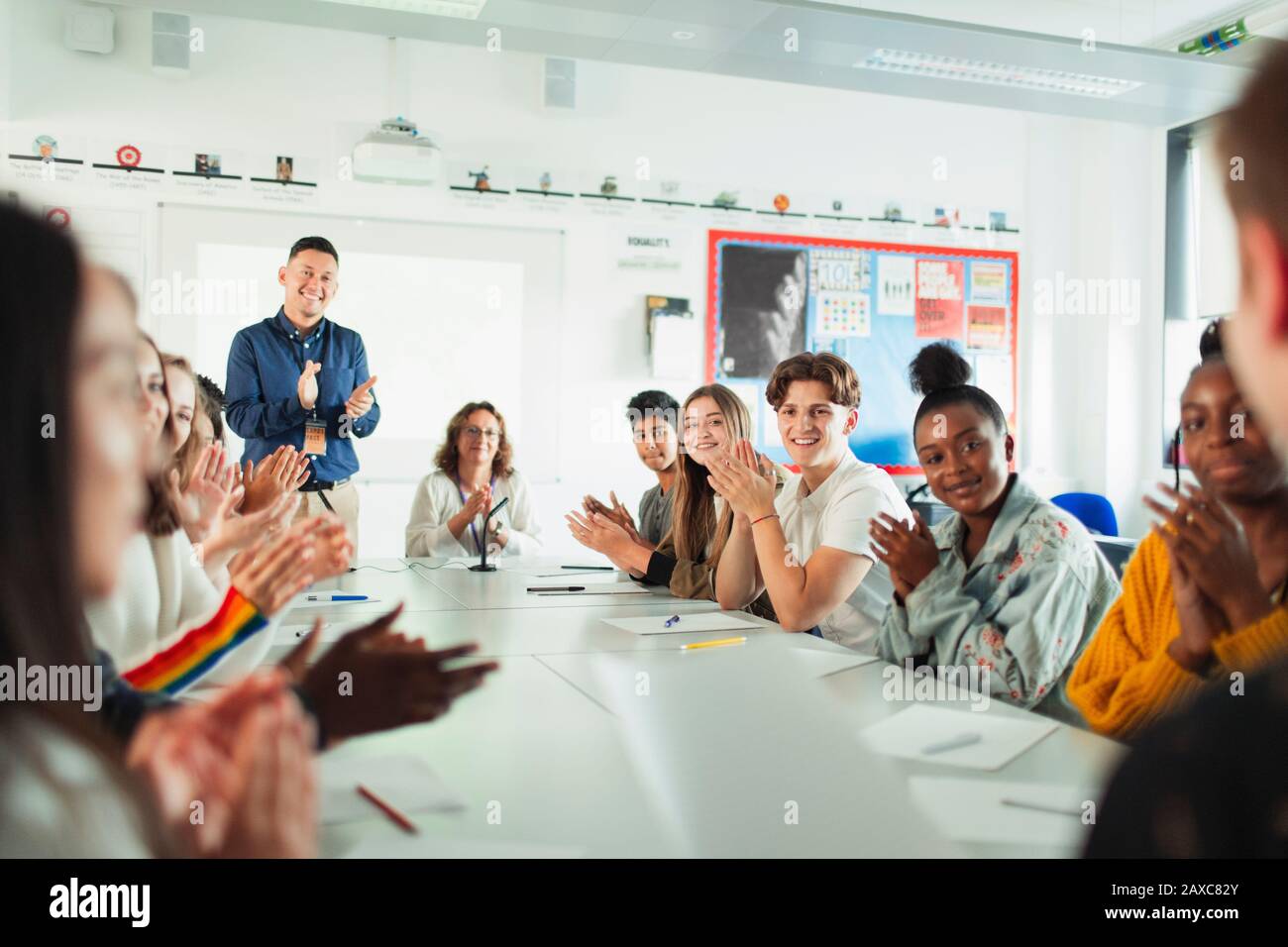 High school students and teacher clapping debate class Stock Photo
