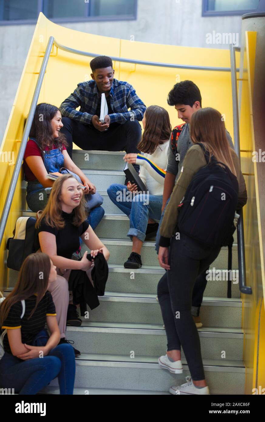 Junior high students hanging out on stairs Stock Photo
