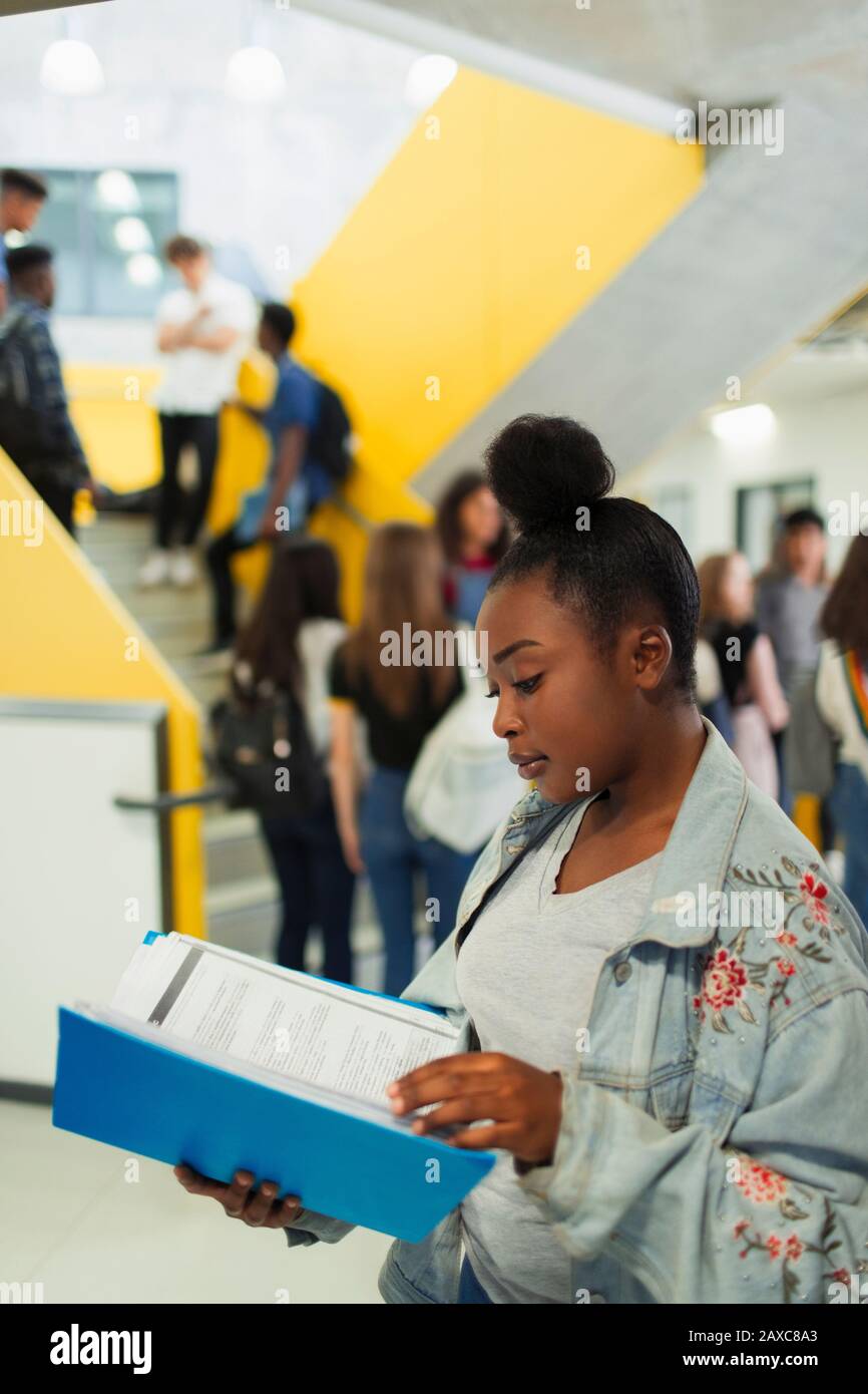 Junior high girl student studying in corridor Stock Photo