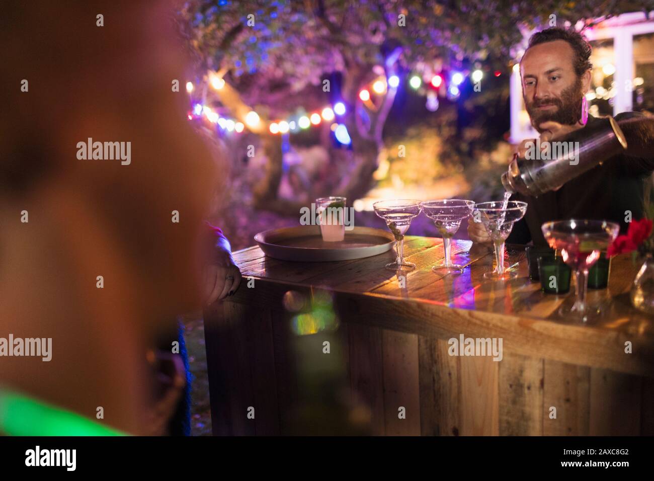 Bartender pouring cocktails at garden party Stock Photo