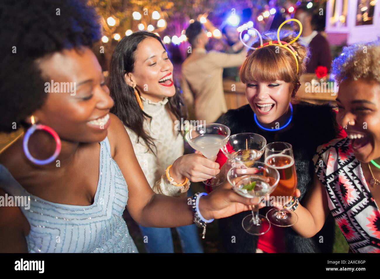 Happy women friends toasting cocktails at party Stock Photo