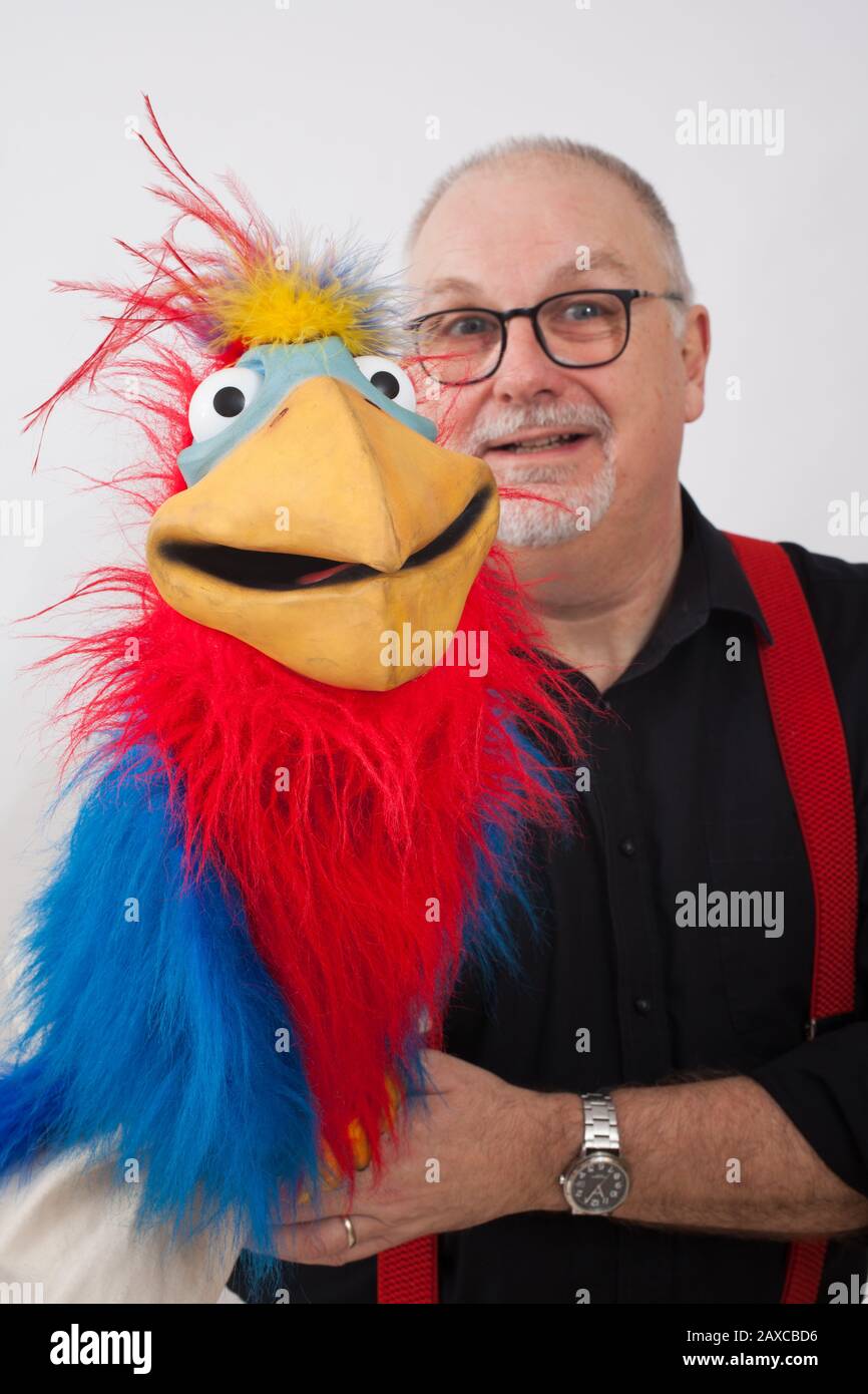 A ventriloquist with a parrot on his arm Stock Photo Alamy