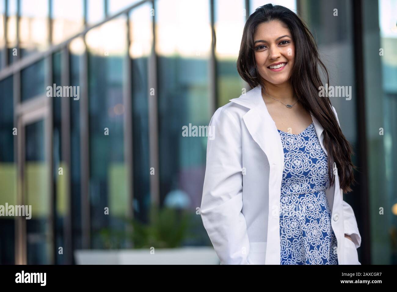 Multiethnic female professional doctor in a white coat standing out side of private practice, possibly physician, dental hygienist, therapist, psychia Stock Photo
