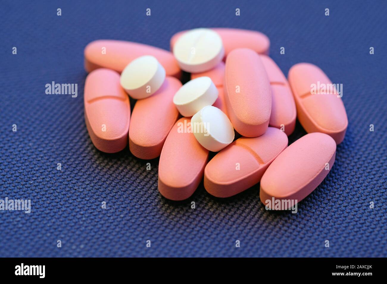 Large pink ovalshaped tablets and small white round tablets. Pills