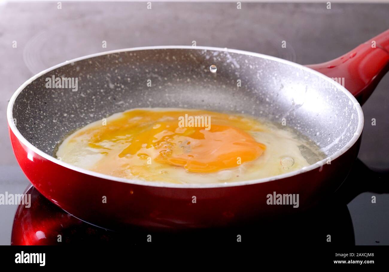 preparing scrambled eggs in a frying pan at home Stock Photo Alamy