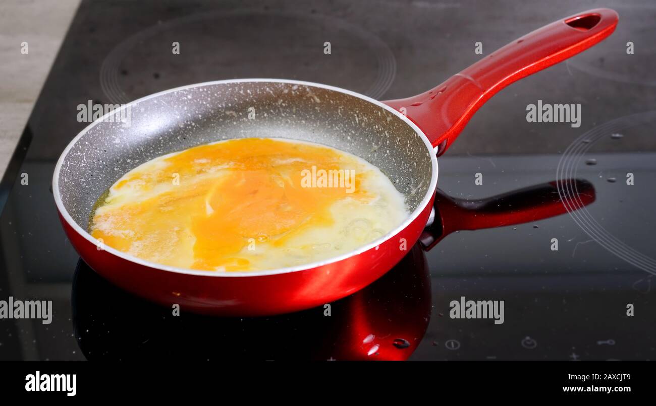 preparing scrambled eggs in a frying pan at home Stock Photo Alamy
