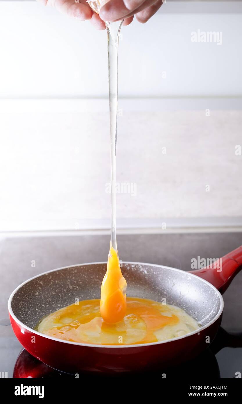 Preparing scrambled eggs - sticking the eggs in the pan Stock Photo