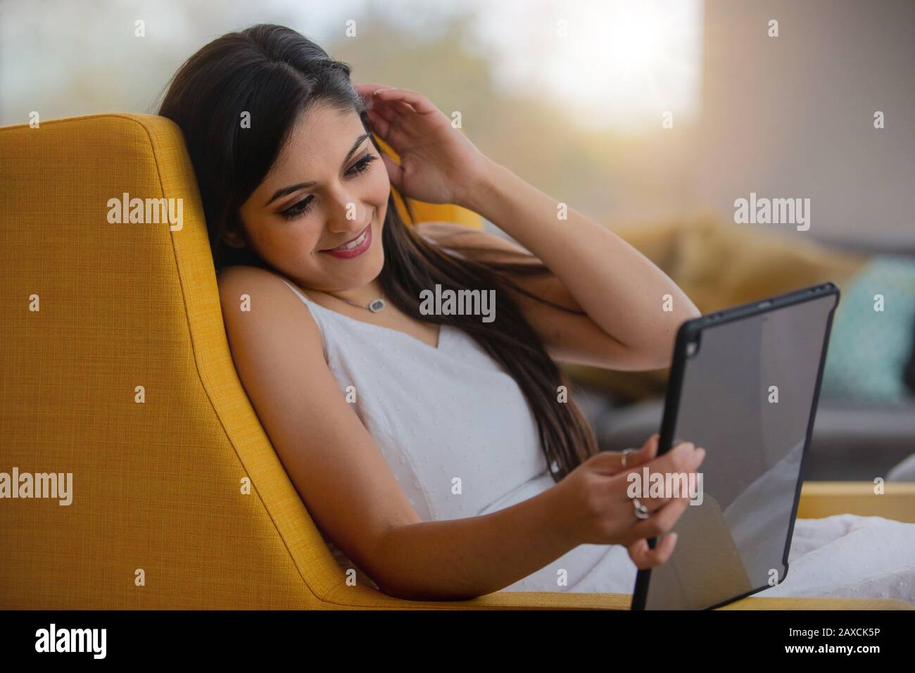 Modern home living lifestyle mixed ethnicity woman, streaming digital content on speedy broadband internet Stock Photo