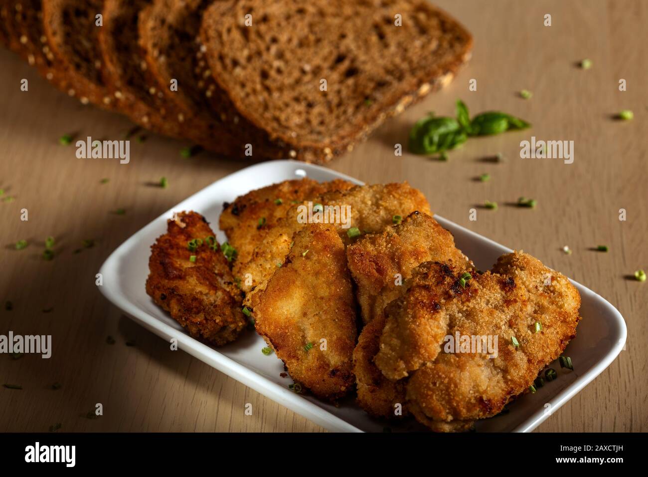 Pieces of pork schnitzel on plate with herbs Stock Photo