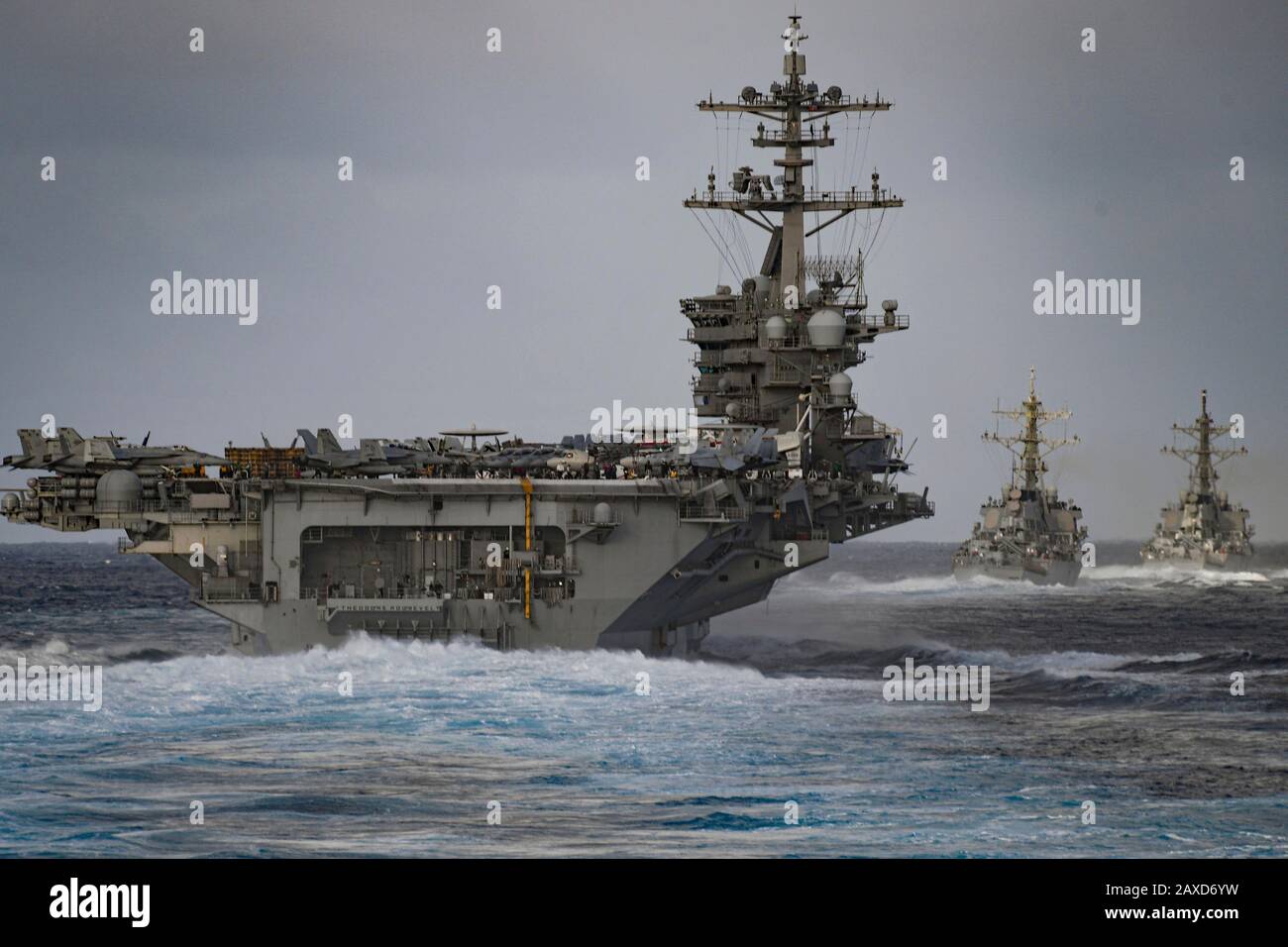 A U.S. Navy Nimitz-class nuclear powered aircraft carrier USS Theodore Roosevelt, Arleigh Burke-class guided-missile destroyers USS Russell and USS Paul Hamilton transits the Pacific Ocean December 2, 2019 in the Pacific Ocean. Stock Photo