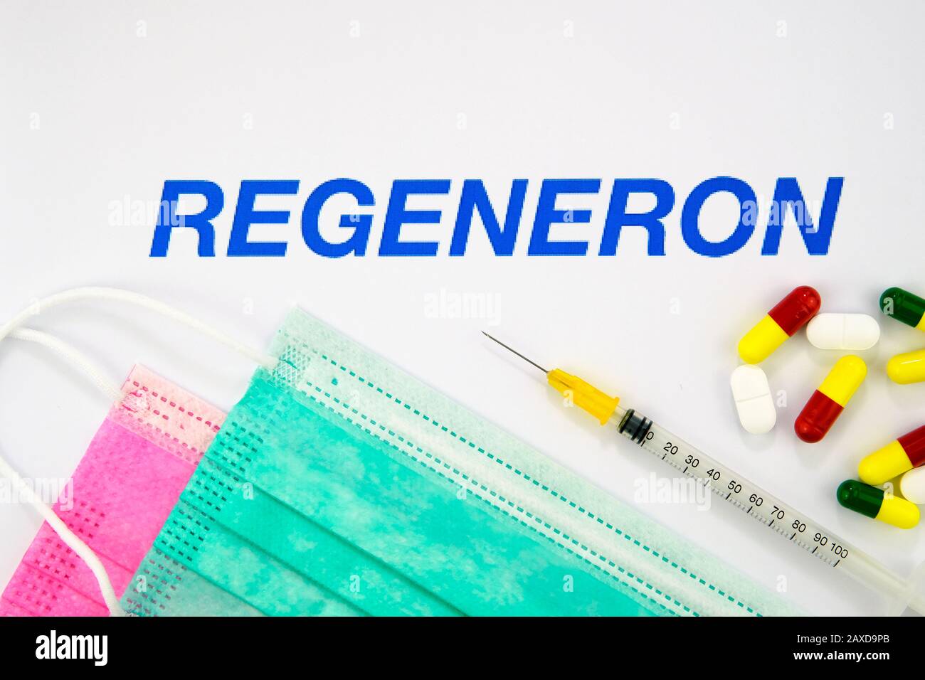 Regeneron Pharmaceuticals company logo seen on the brochure with the viral masks, syringe and pills. Concept photo Stock Photo