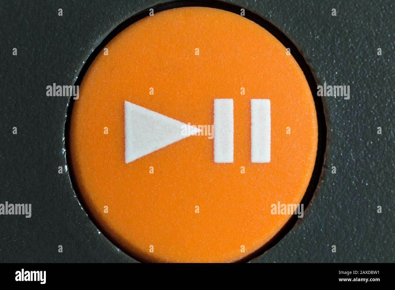 Macro close up photograph of orange play or pause button on vintage portable tape player. Stock Photo