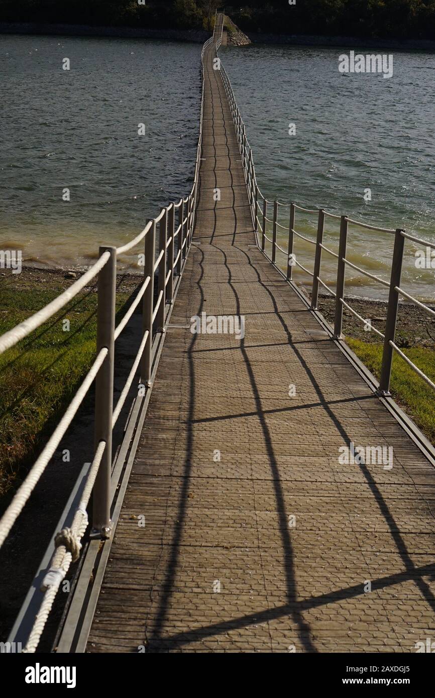 A footbridge across a lake on a summers day Stock Photo