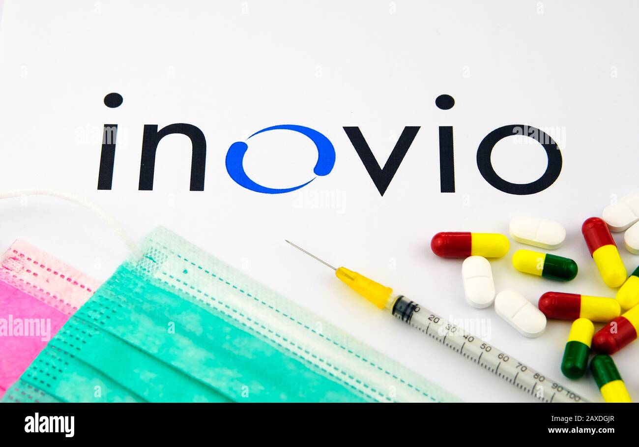 Inovio Pharmaceuticals company logo seen on the brochure with the viral masks, syringe and pills. Concept photo. Stock Photo