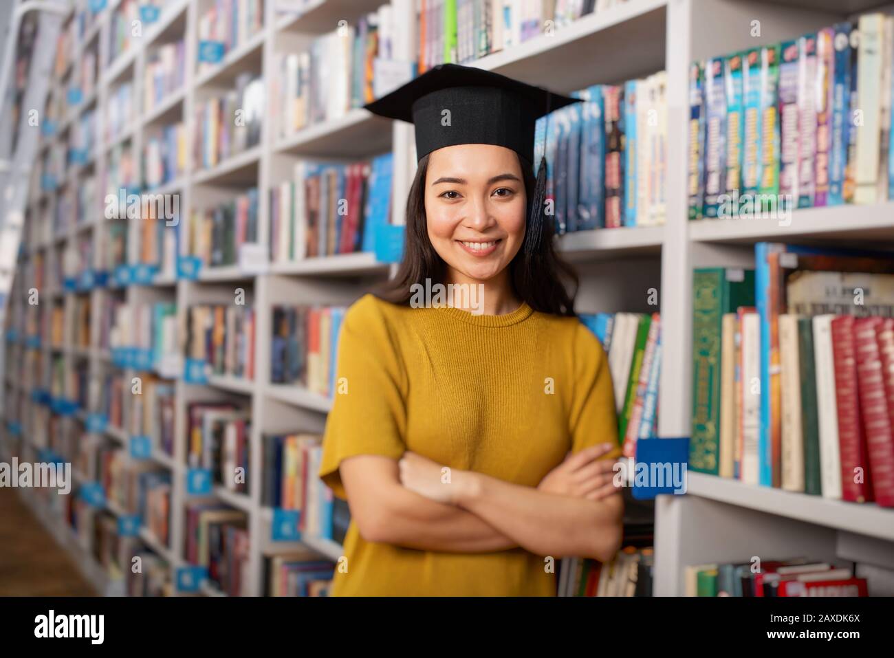 Graduate girl in front of a library. Concept of preparation and determination Stock Photo