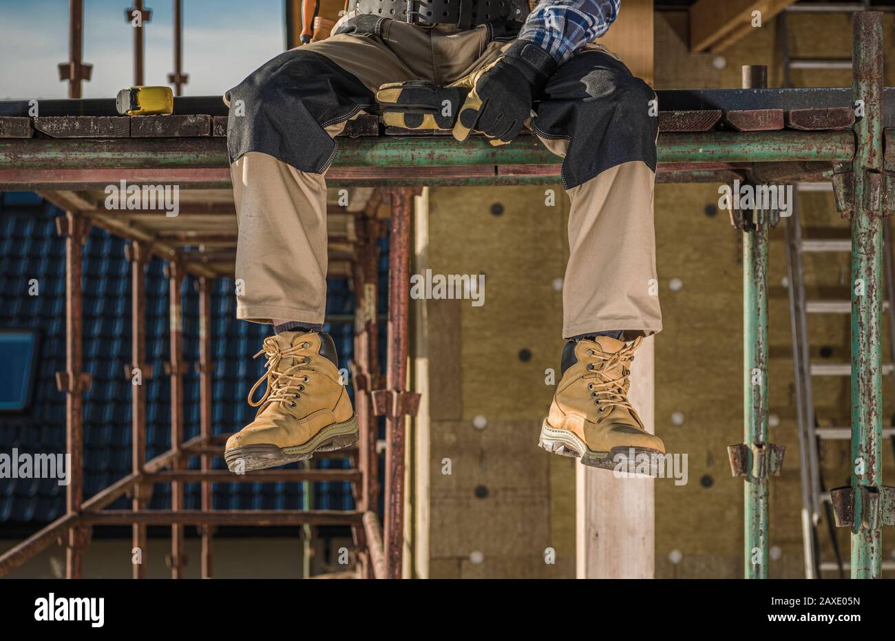 Working on a Scaffolding. Construction Worker Taking Short Break. Industrial Concept. Stock Photo