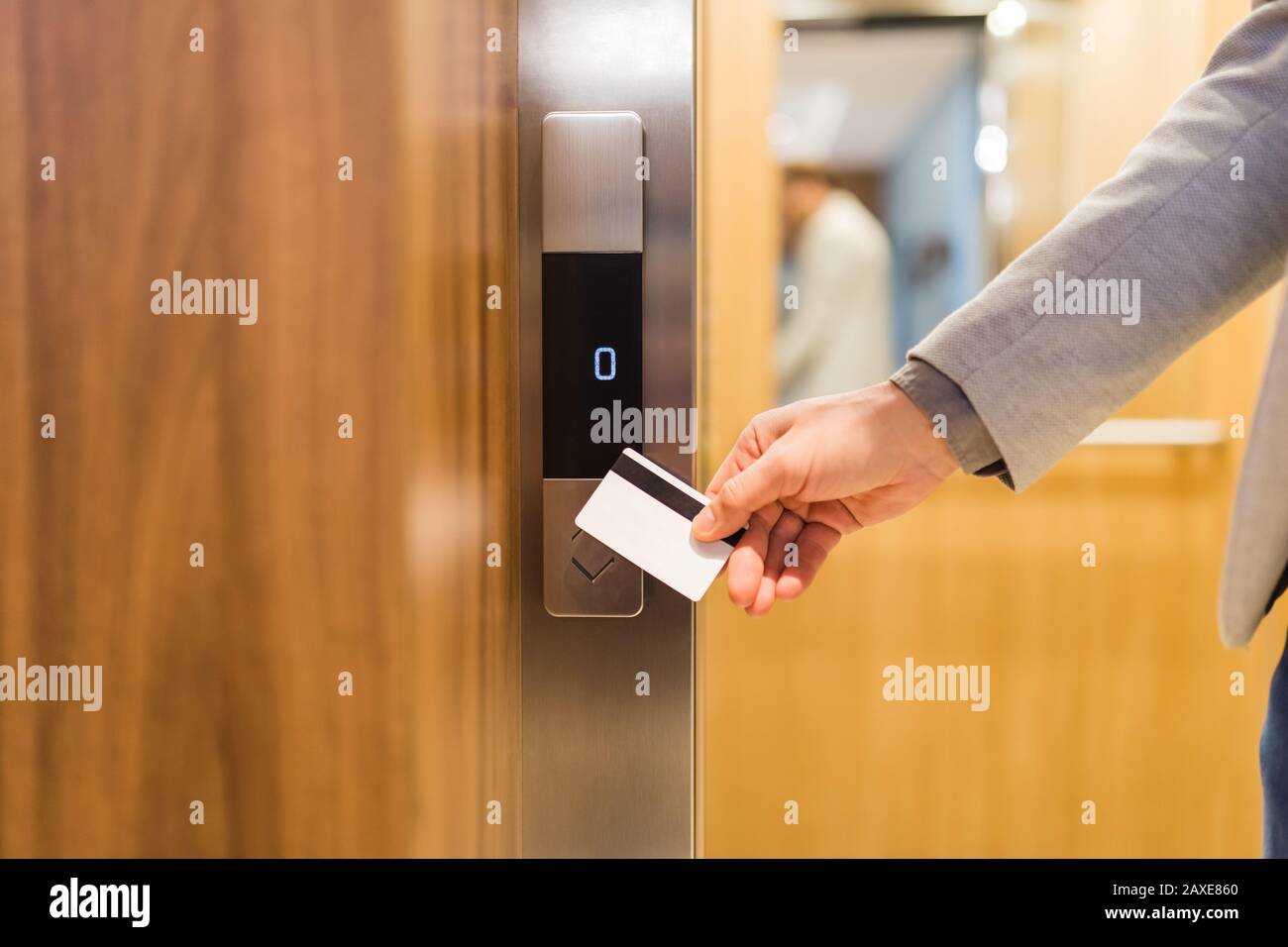 Close up of businessman hand holding key card to unlock elevator access