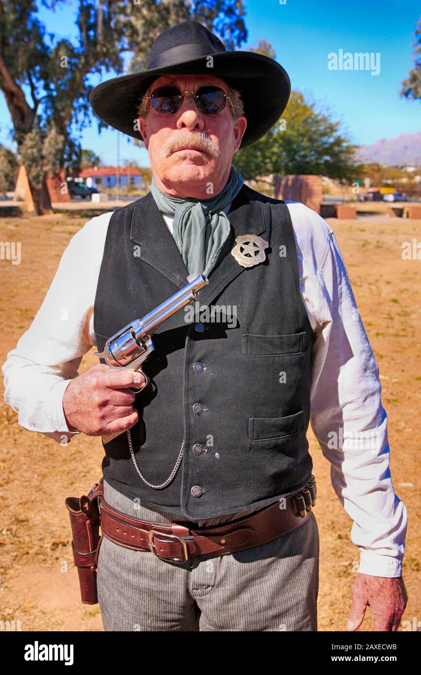 Re-enactor wearing a US Marshal tin star and holding a Colt Peacemaker at an event in Tucson AZ Stock Photo