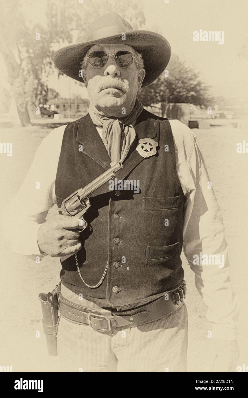 Re-enactor wearing a US Marshal tin star and holding a Colt Peacemaker at an event in Tucson AZ Stock Photo