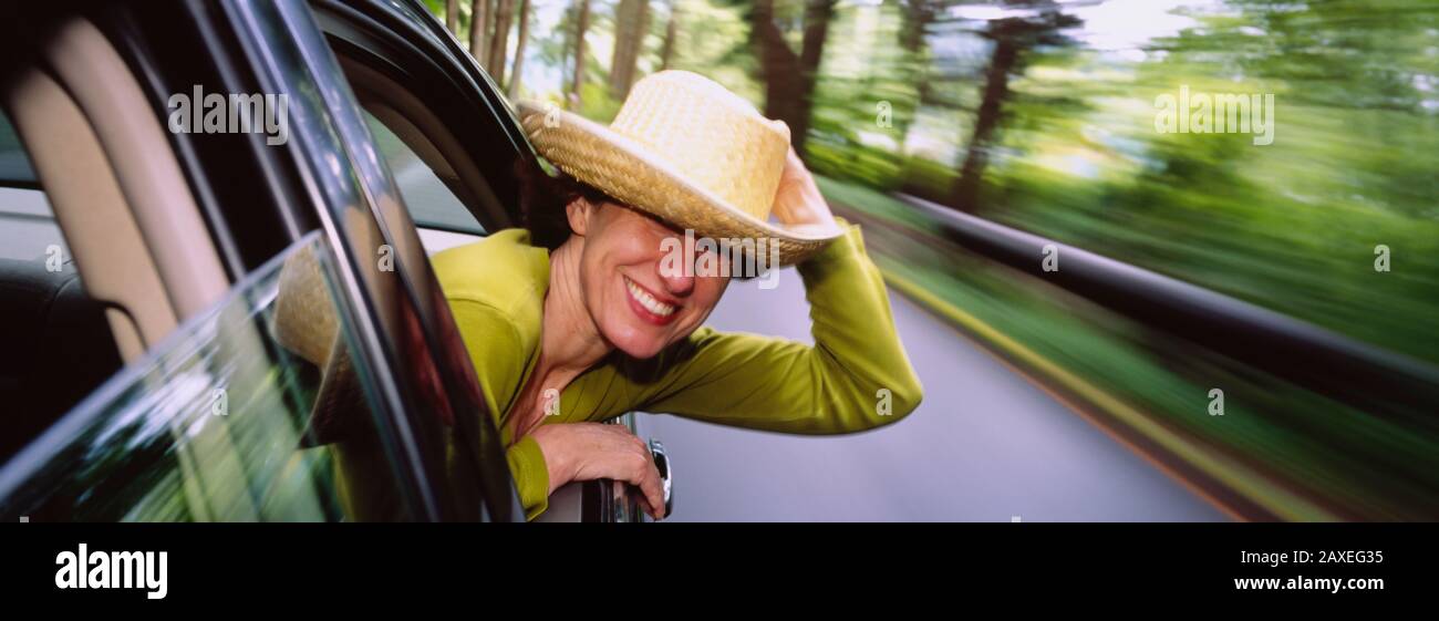 Mid Adult Woman Leaning Out Of A Moving Car, Washington State, USA Stock Photo