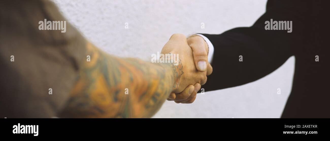Close-Up Of Two Men Shaking Hands, Germany Stock Photo