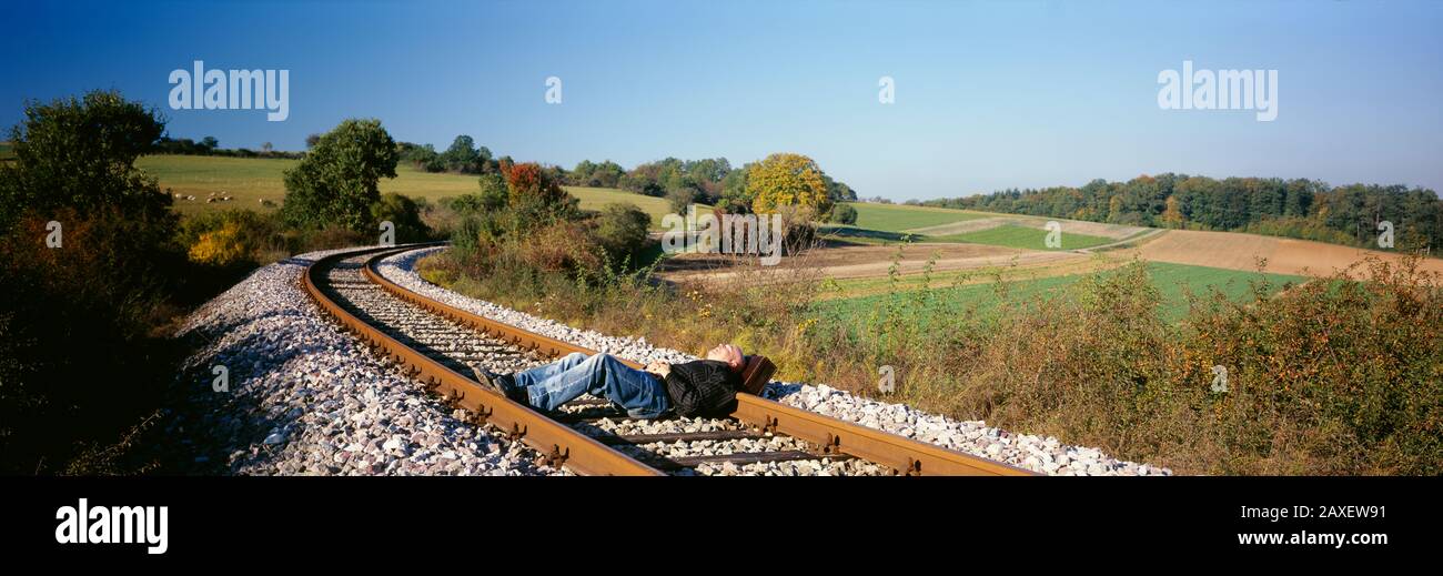 Man sleeping on a railroad track, Germany Stock Photo