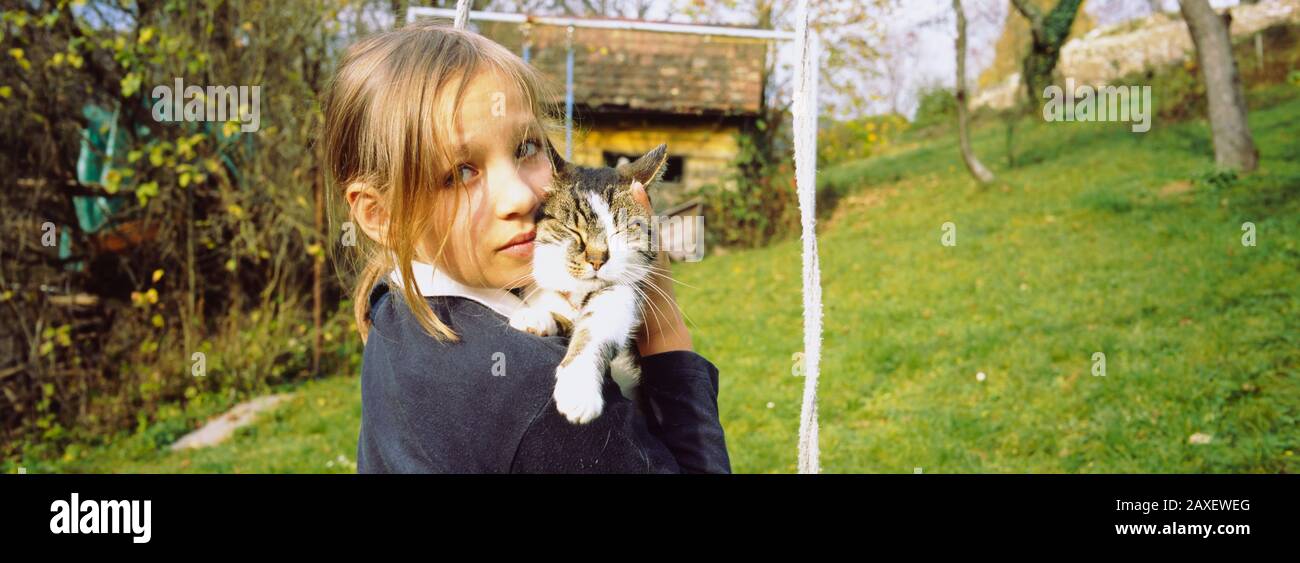 Portrait of a girl carrying her cat, Germany Stock Photo Alamy