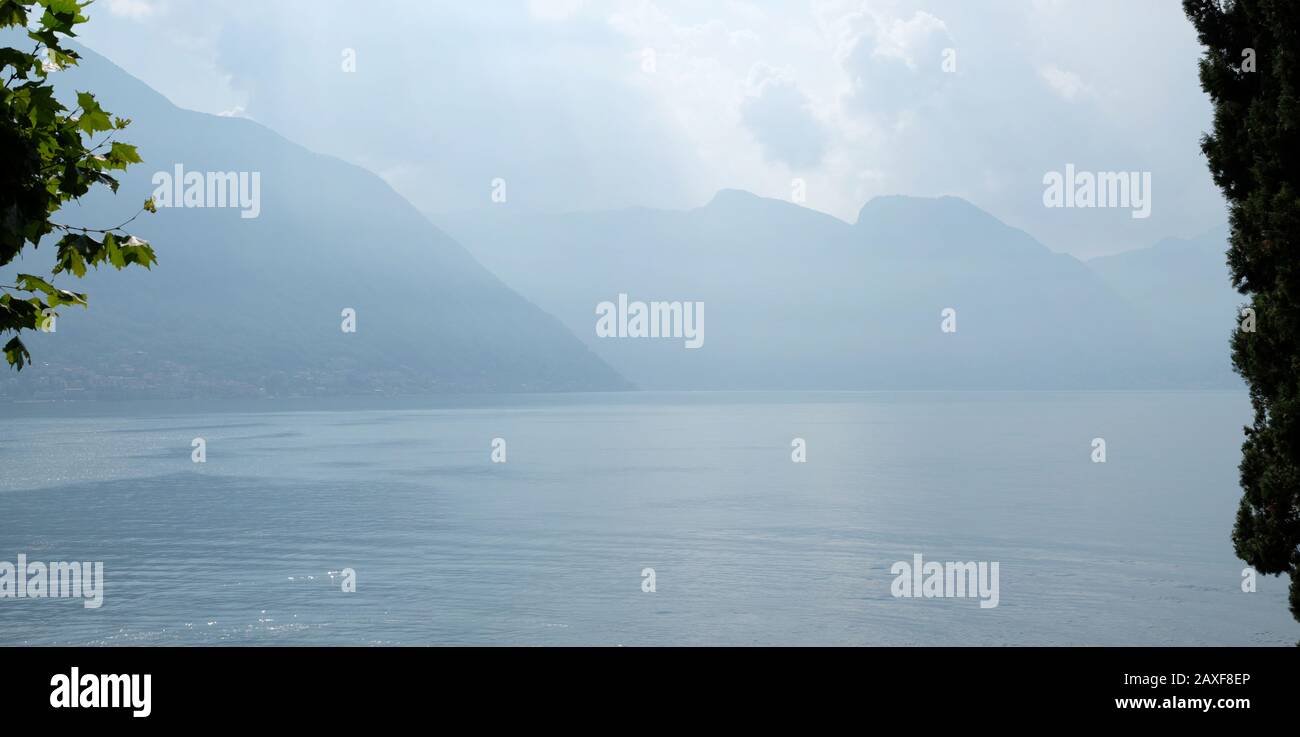Panorama of Lake Como, Lombardy Italy, across the water of the beautiful lake, villages, cloud shrouded mountains and dramatic scenery Stock Photo
