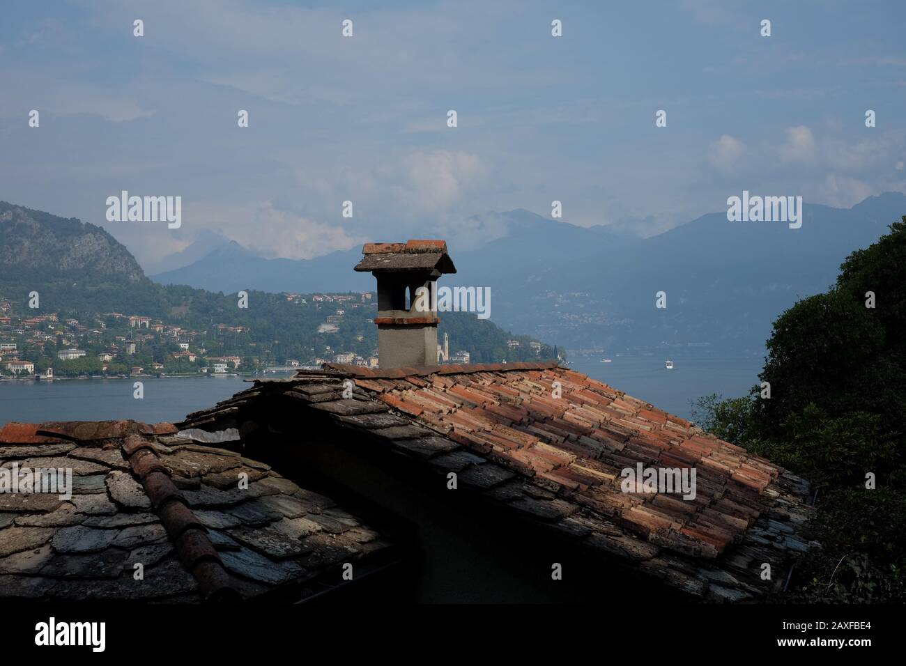 Looking out over a traditional stone roof Lake Como, Italy, a lake of picturesque villages, luxurious villas, palazzo, resorts dramatic scenery Stock Photo