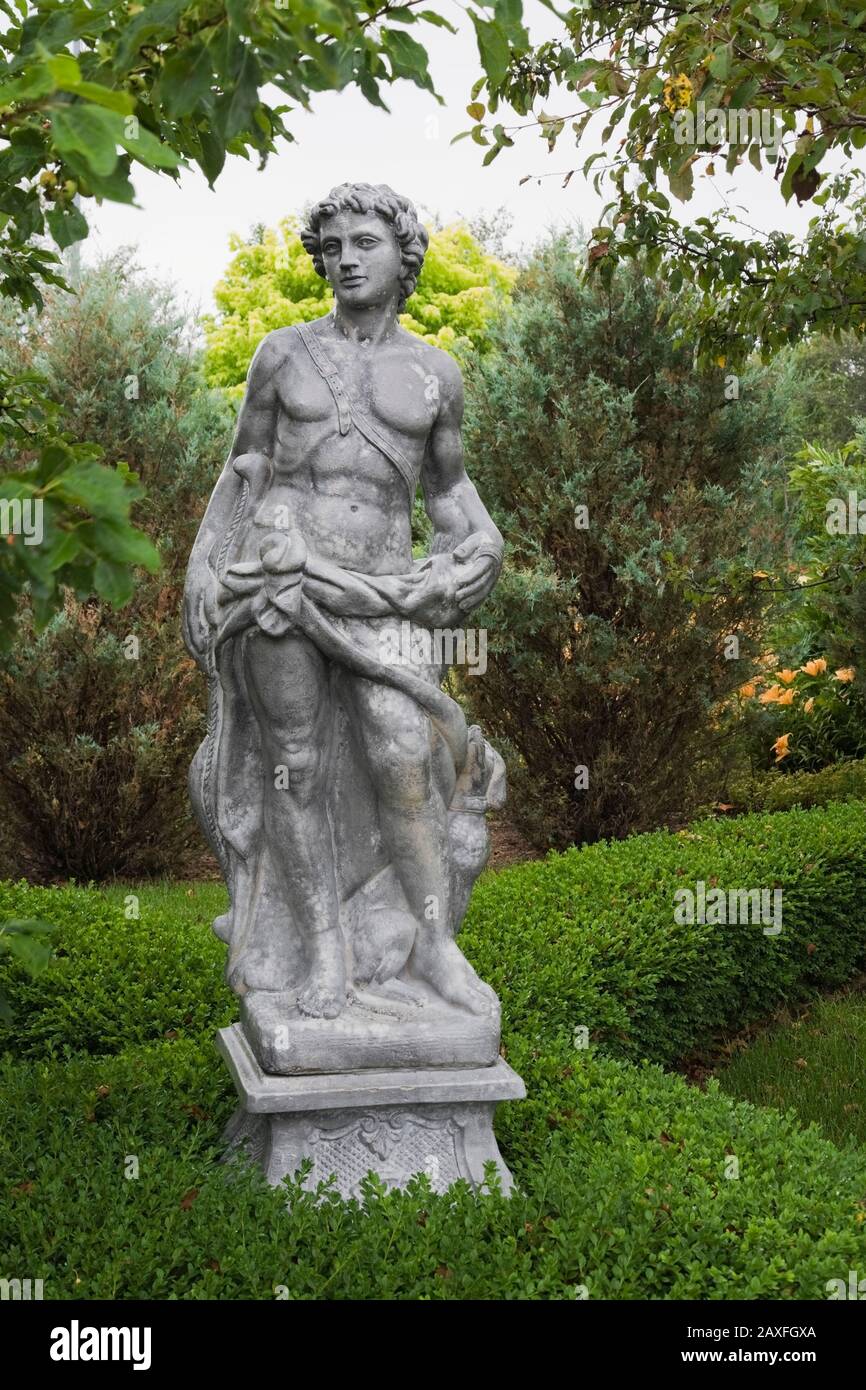 Grey concrete statue of Apollo in the Five Senses Garden in the La Seigneurie de L'Ile d'Orleans private estate garden in summer Stock Photo
