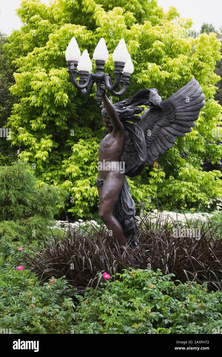 Bronze angel lamppost sculpture and Acer negundo 'Kelly's Gold' - Maple tree in the Five Senses Garden in the La Seigneurie de L'Ile d'Orleans. Stock Photo