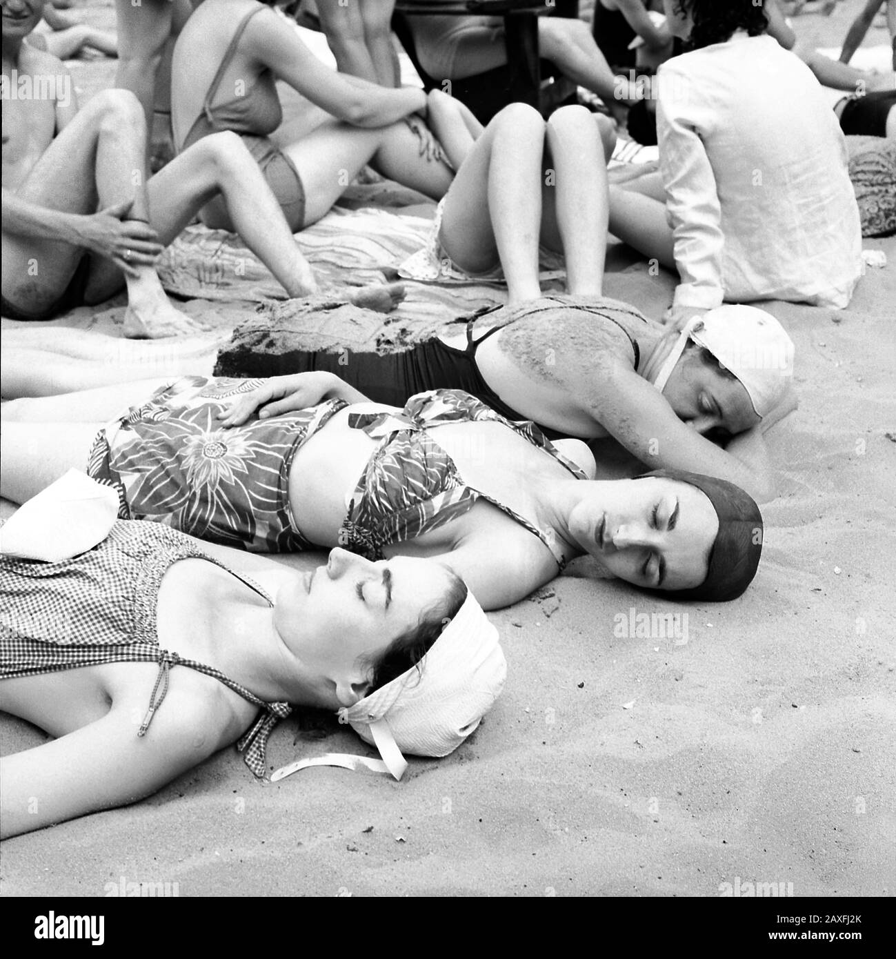 1943 , july , Glen Echo ,  Maryland , USA : Sun bathers on the sand beach at the swimming pool in the Glen Echo amusement park .  Photo by woman photographer Esther Bubley - UNITED STATES  - FOTO STORICHE - HISTORY - GEOGRAFIA - GEOGRAPHY  - ANNI QUARANTA - 1940's - 40's - '40 - STOCK - DONNA - DONNE in COSTUME DA BAGNO - SWIMSUIT - sabbia - sand - spiaggia - beach - mare - sea - VACANZA - VACANZE - HOLIDAYS - sleeping beauties beauty - bellezza - bellezze al bagno - cuffia di plastica - SONNO - SOGNO - DREAM - DONNE addormentate - women - donna - woman - BAGNANTI - due pezzi - bikini - seni - Stock Photo