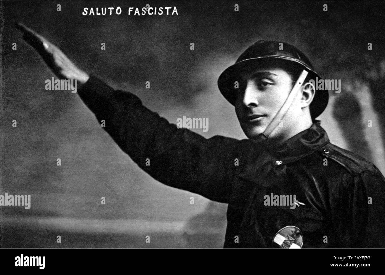 1922 ca , ITALY : Italian postcard , a Black Shirt make the fascist salute at arm raised - PROPAGANDA - FASCISMO - FASCISTA - FASCISM - ANNI VENTI - SALUTO - ITALIA  - 20's - '20  - portrait - ritratto -   helmet - elmetto  - BLACK SHIRT - CAMICIA NERA - FOTO STORICHE - HISTORY PHOTOS - STOCK  - ITALY - ITALIA - XX CENTURY - NOVECENTO - cartolina © Archivio GBB / Stock Photo