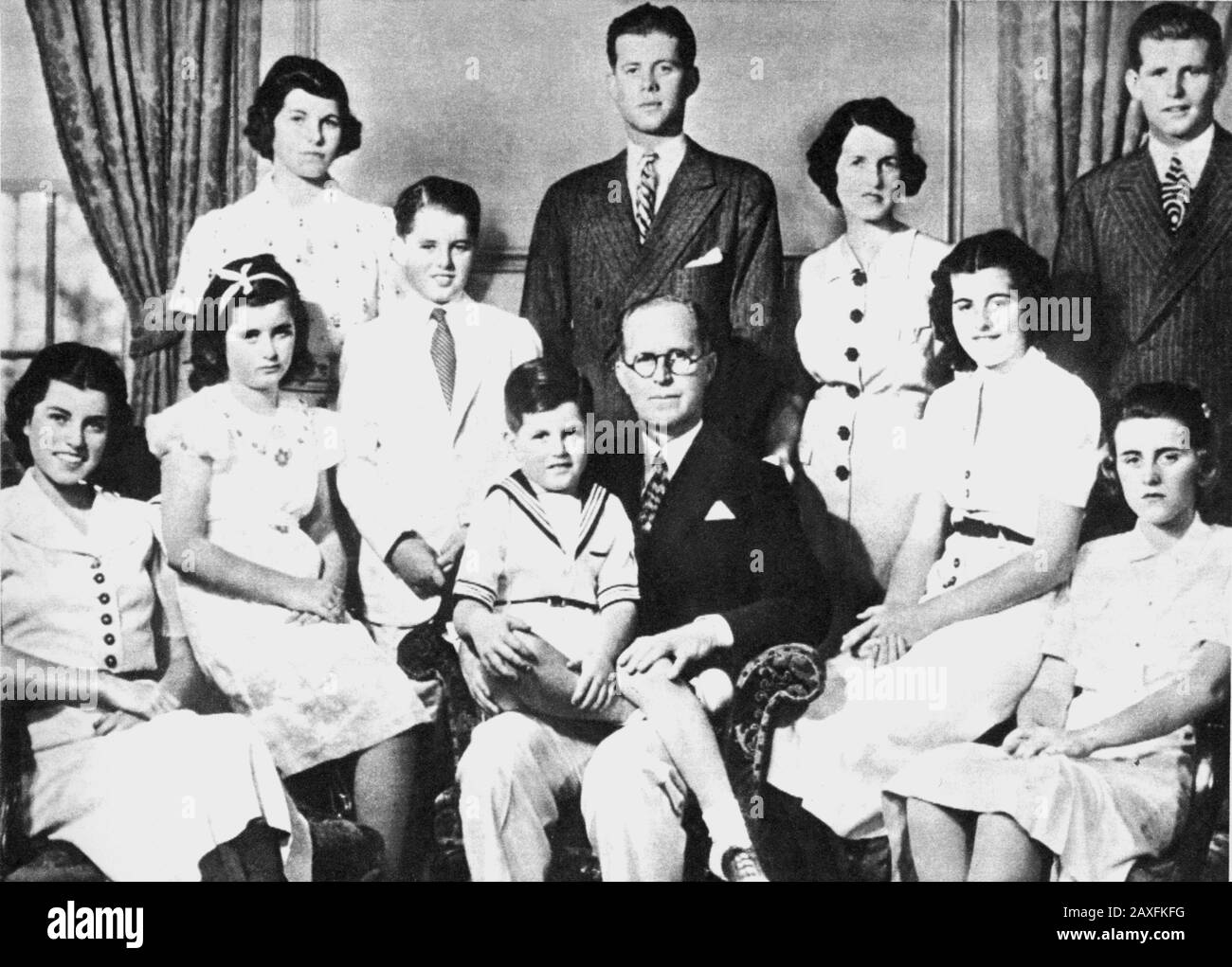 1943 ca , New York , USA : The american JOHN KENNEDY future president of US with all the family. From the left: EUNICE and Jean seated , ROBERT with white dress , EDWARD seated on his father JOSEPH , PATRICIA and KATHLEEN  . Standing from left : ROSEMARY , JOHN , the mother ROSE and JOSEPH Jr  - PRESIDENTE DEGLI STATI UNITI D' AMERICA - cravatta  - tie - CASA BIANCA - WHITE HOUSE - POLITICO - POLITIC - POLITICIAN - POLITICA  - ARCHIVIO GBB © Archivio GBB / Stock Photo