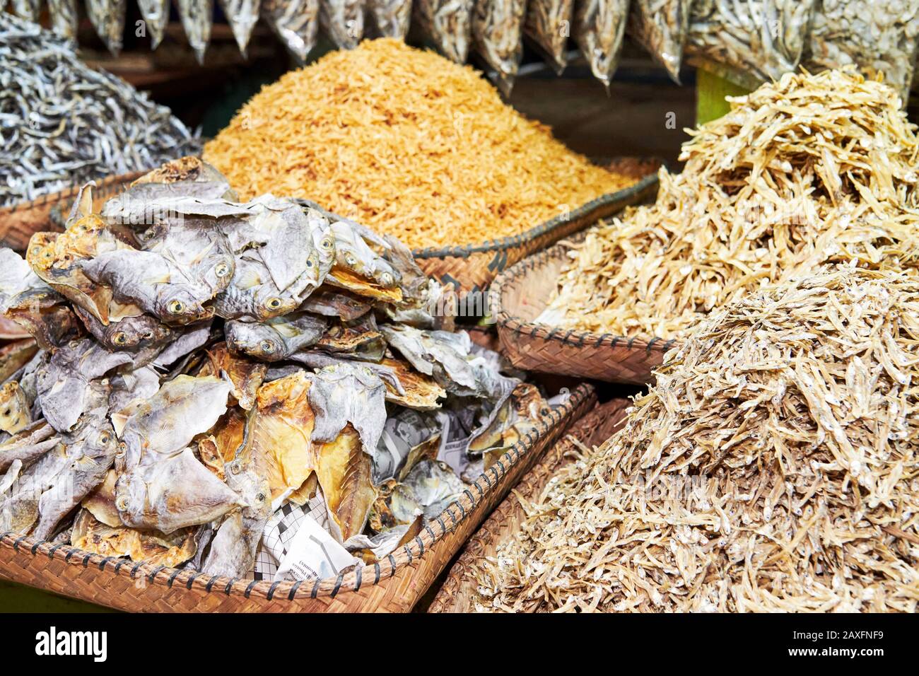 Close-up of heaps of dried and salted small fishes in bamboo baskets at the Central Wet Market in Iloilo, a local delicacy in the Philippines, Asia Stock Photo