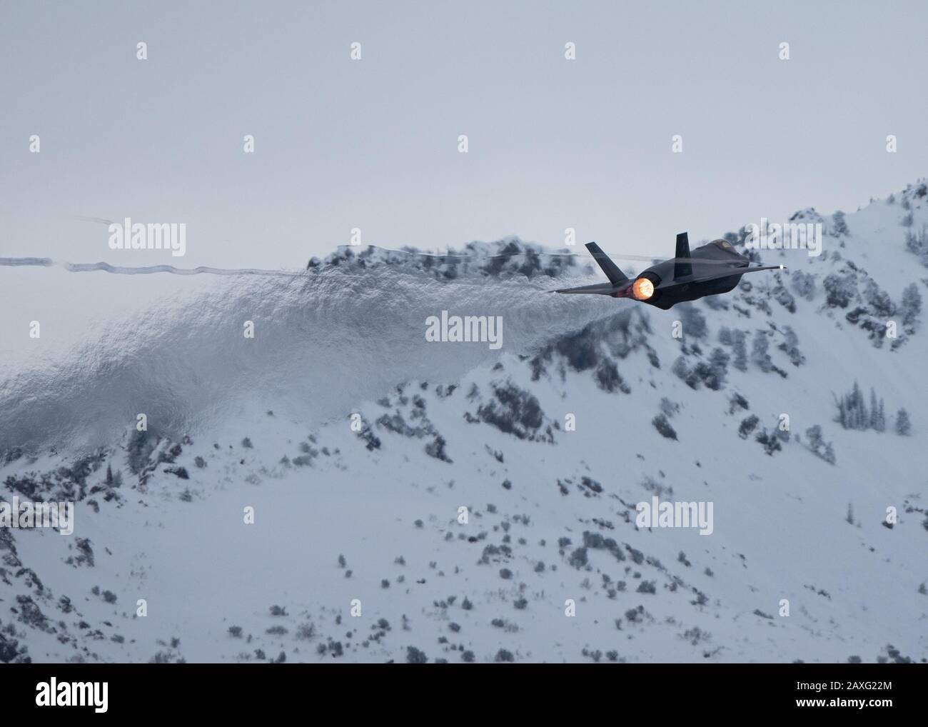 An F-35A Lightning II soars by some mountains at Hill Air Force Base ...