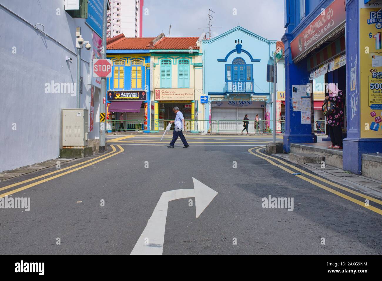 A pedestrian crossing Dunlop Street in Little India, Singapore, colorful old shophouses in the main thoroughfare Serangoon Road. in the background Stock Photo