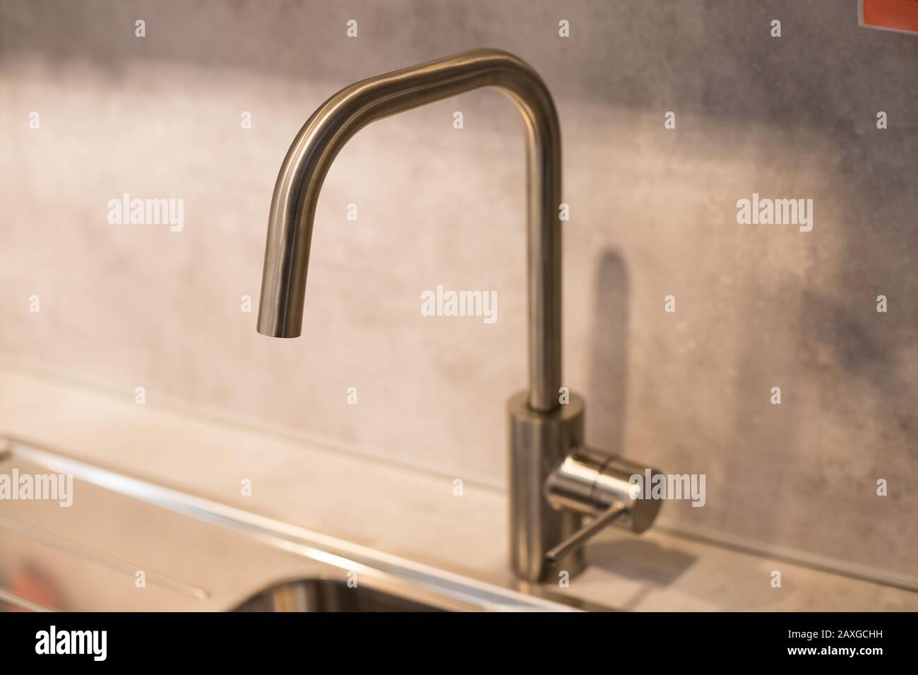 Kitchen Sink Of Dark Gray Stone With Chrome Faucet In A Clean