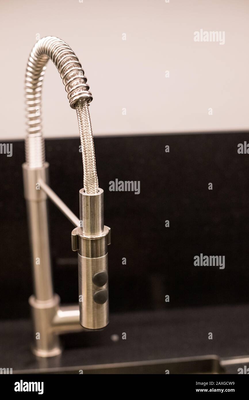 Kitchen Sink Of Dark Gray Stone With Chrome Faucet In A Clean