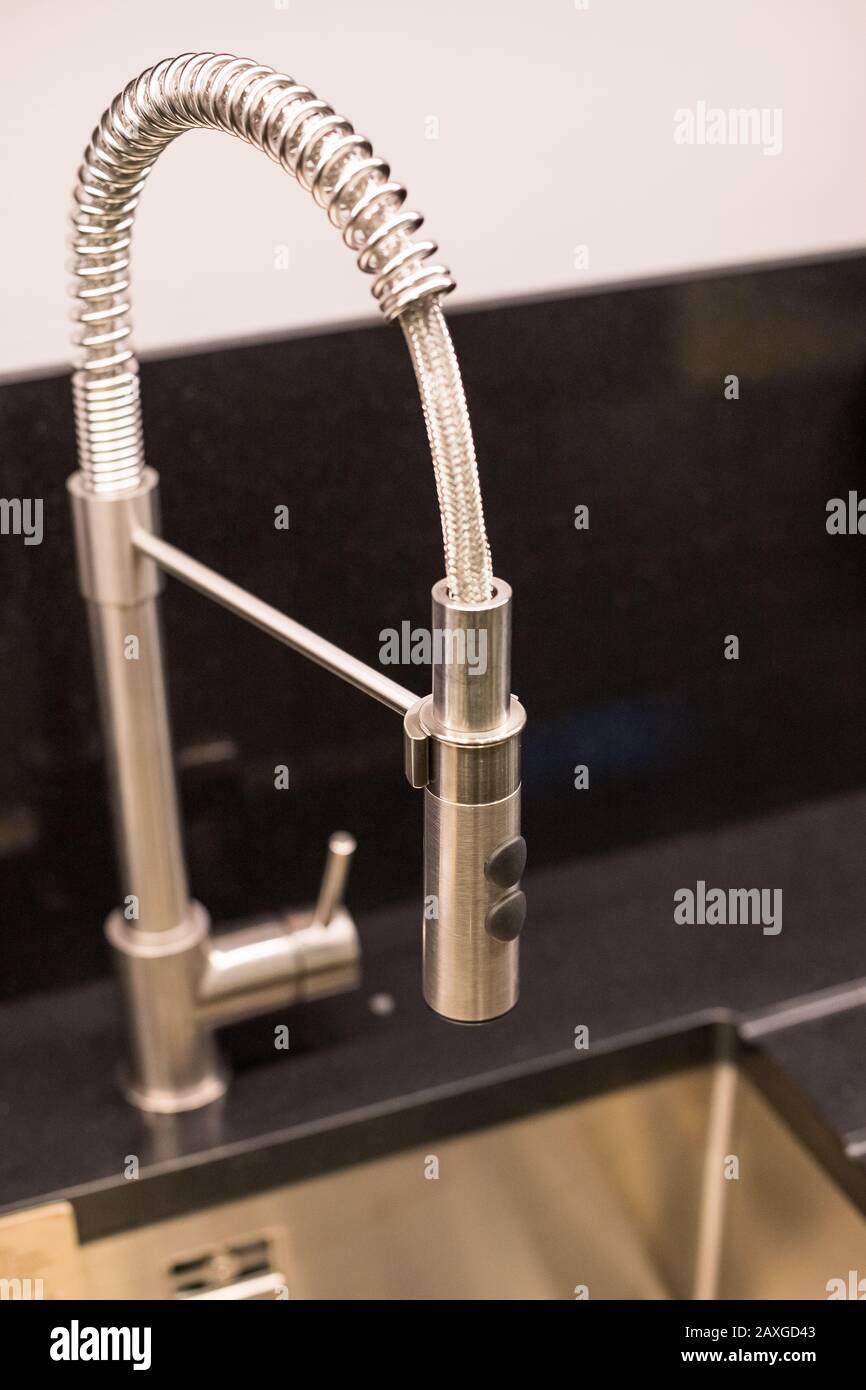Kitchen Sink Of Dark Gray Stone With Chrome Faucet In A Clean