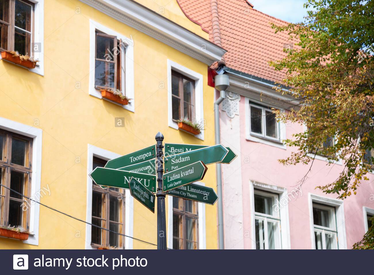 Arrow Direction Sign With Old Town Colorful Buildings In Tallinn