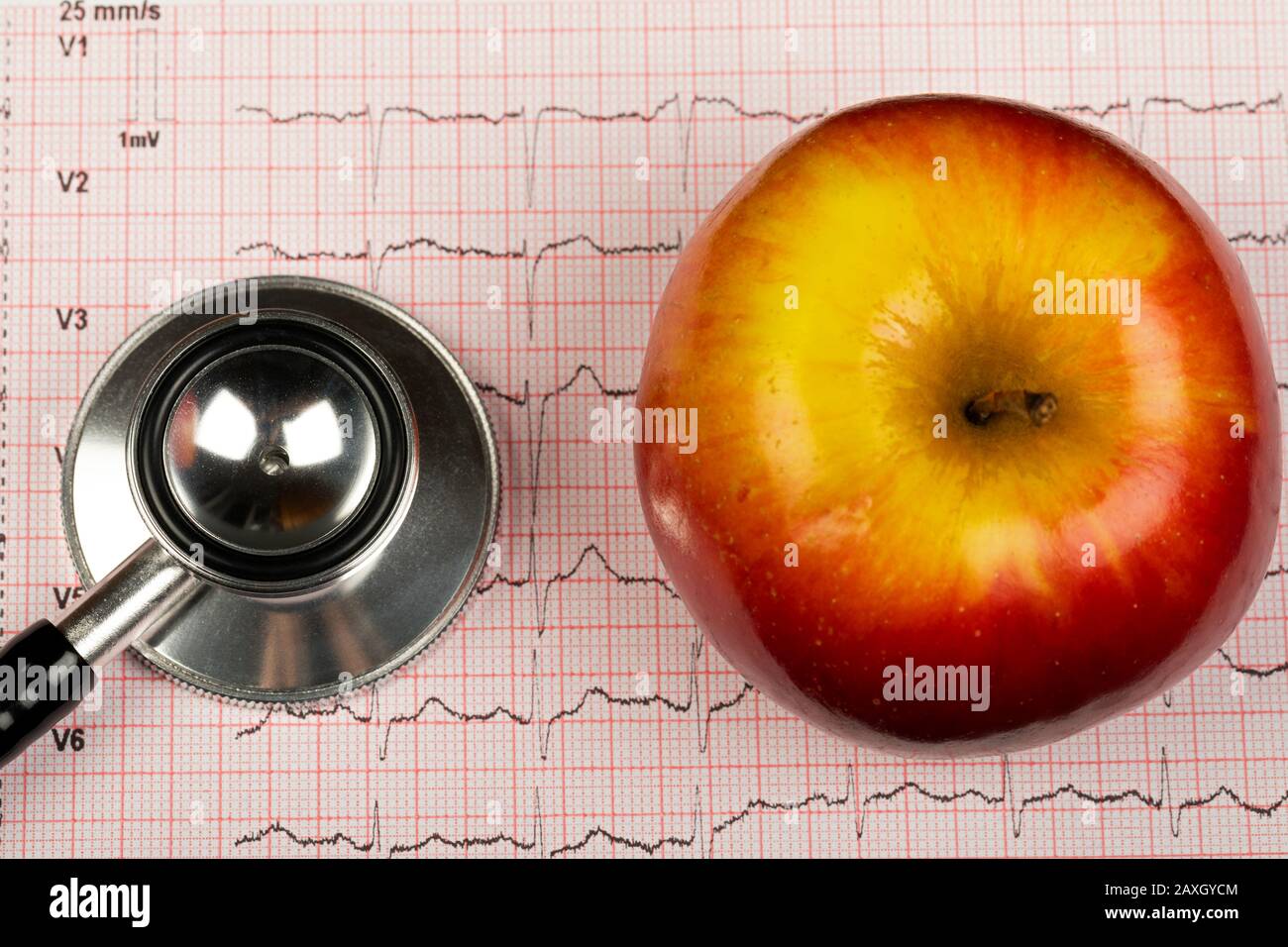 Electrocardiogram graph report with stethoscope and apple on it Stock Photo