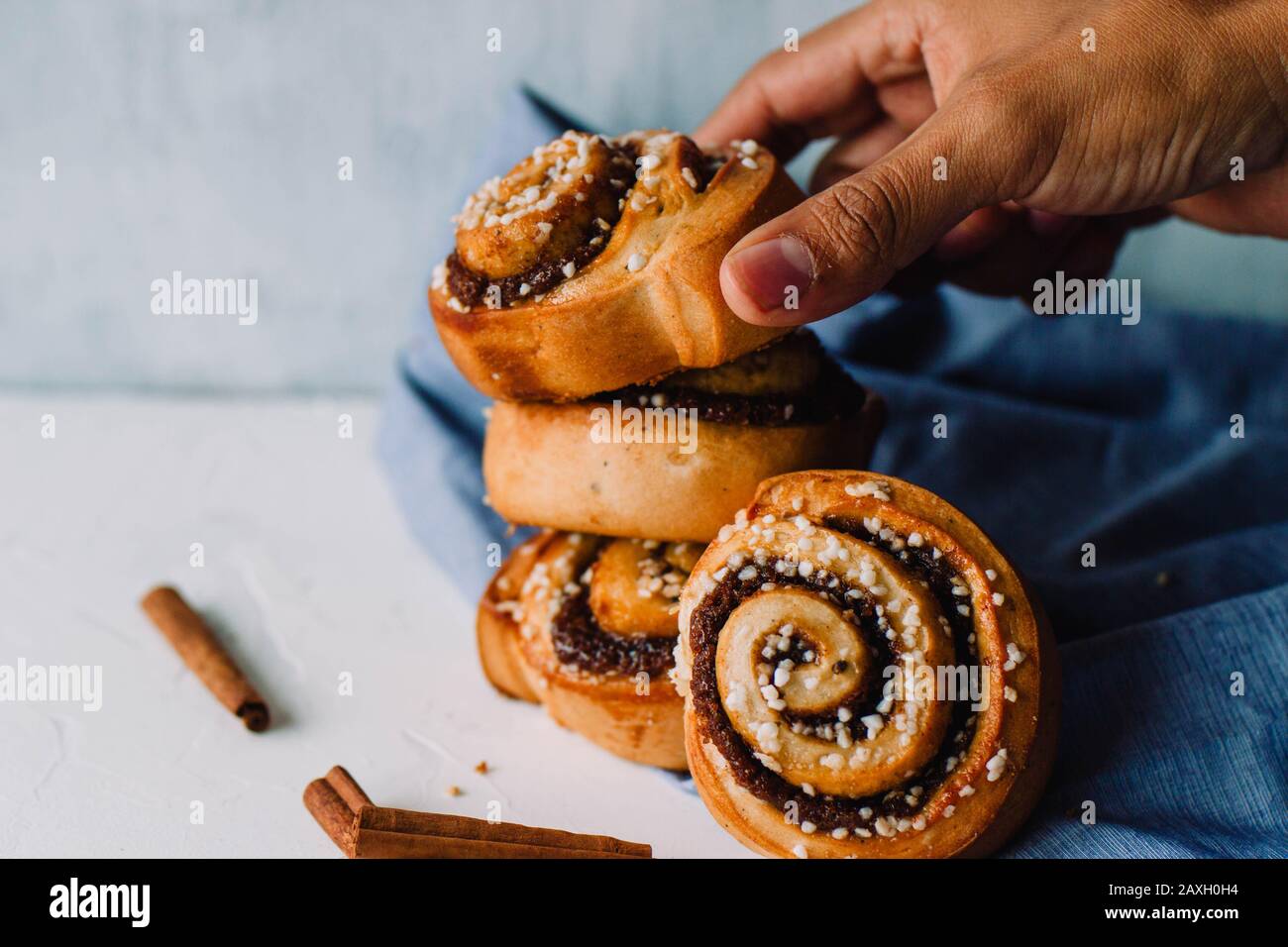 Hand holding cinnamon rolls on a white background Stock Photo